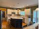Bright kitchen features white cabinets, stainless steel appliances, kitchen island with breakfast bar and wood floors at 13221 Griffin Run, Carmel, IN 46033