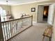 Bright upstairs landing with wooden railing and view to room beyond double doors at 13221 Griffin Run, Carmel, IN 46033