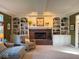 Living room with a brick fireplace flanked by built-in shelves and cabinets, plus a comfy arm chair at 13221 Griffin Run, Carmel, IN 46033