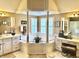 Bright, luxurious Primary bathroom with a corner tub framed by pillars, and double vanity with ample counter space at 13221 Griffin Run, Carmel, IN 46033