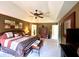 Spacious main bedroom features a tray ceiling, a ceiling fan, a king-size bed and a door to the en suite bathroom at 13221 Griffin Run, Carmel, IN 46033