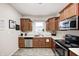 Well-lit kitchen features stainless steel appliances, wooden cabinetry, and a double basin sink at 1331 Mccormicks Cir, Danville, IN 46122