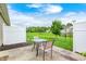 View of the concrete patio with outdoor seating in the fenced backyard under cloudy skies at 1331 Mccormicks Cir, Danville, IN 46122