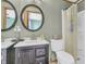 Nicely appointed bathroom with double sinks, round mirrors, and a shower with a curtain at 1357 Brownswood Dr, Brownsburg, IN 46112