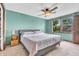 Spacious bedroom with a ceiling fan and light fixture, soft carpet, and a view of the outside at 1357 Brownswood Dr, Brownsburg, IN 46112