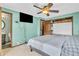 Bright bedroom featuring a ceiling fan, television, walk-in closet, and ensuite bathroom at 1357 Brownswood Dr, Brownsburg, IN 46112