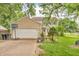 Charming two-story home with tan siding, attached garage and well-manicured lawn and garden in front at 1357 Brownswood Dr, Brownsburg, IN 46112