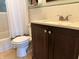 Angle view of the bathroom with vanity, sink, toilet, and shower with white shower curtain at 1433 N Colorado Ave, Indianapolis, IN 46201