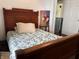 View of a bedroom with a carved wood headboard and bed frame, plus a white and green quilt at 1433 N Colorado Ave, Indianapolis, IN 46201