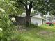 A detached one car garage sits at the back of a grassy yard with a wooden fence at 1433 N Colorado Ave, Indianapolis, IN 46201