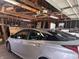 View inside the garage showing a silver vehicle, rafters, and miscellaneous storage items at 1433 N Colorado Ave, Indianapolis, IN 46201