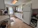 Bright kitchen with white cabinets, tile floors, white appliances, and a window at 1433 N Colorado Ave, Indianapolis, IN 46201