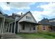 Exterior view of a two-story home with a covered porch among other houses needing renovation at 1601 Spann Ave, Indianapolis, IN 46203