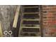 Unfinished basement stairwell, featuring wooden steps and brick walls awaiting future renovation and completion at 1601 Spann Ave, Indianapolis, IN 46203