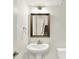 A bathroom featuring a pedestal sink and a mirror reflecting a view of carpeted stairs at 16057 Coleman Dr, Westfield, IN 46074