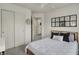 Well-lit bedroom with a closet with sliding doors, a full sized bed, modern accents, and a view to the bathroom at 16057 Coleman Dr, Westfield, IN 46074