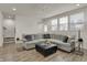 Cozy living room with a large sectional sofa, ottoman, and open layout to the kitchen area at 16057 Coleman Dr, Westfield, IN 46074