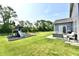 Backyard featuring a playground, patio with seating, and lush greenery, perfect for outdoor enjoyment at 17390 Tribute Row, Noblesville, IN 46060