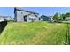 Large backyard showcasing lush green grass, modern gray siding, black fencing, and a playset at 17390 Tribute Row, Noblesville, IN 46060