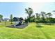 Backyard features a playground with slide and swing set, surrounded by lush green grass and a secure fence at 17390 Tribute Row, Noblesville, IN 46060