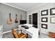 Featuring a bright home office, with guitar wall art, a gray accent wall, and french doors at 17390 Tribute Row, Noblesville, IN 46060