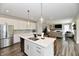 Open-concept kitchen with island seating that flows into a cozy living area, great for entertaining at 17390 Tribute Row, Noblesville, IN 46060