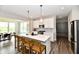 Modern kitchen with white cabinets, an island with seating, and stainless steel appliances at 17390 Tribute Row, Noblesville, IN 46060