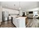 Open concept kitchen with white cabinets, stainless steel appliances, and large island at 17390 Tribute Row, Noblesville, IN 46060