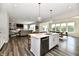 Bright kitchen with stainless steel appliances, large island, and open to the dining and living area at 17390 Tribute Row, Noblesville, IN 46060