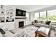 Cozy living room with a fireplace, built-in shelving, and comfortable seating arrangement at 17390 Tribute Row, Noblesville, IN 46060
