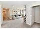 Open-concept living area with a neutral color scheme and plush carpeting with cozy sofa and pictures at 17390 Tribute Row, Noblesville, IN 46060