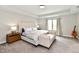 Bright main bedroom featuring a king-size bed, tray ceiling, and a sun-filled window at 17390 Tribute Row, Noblesville, IN 46060