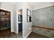 Mudroom with custom gray cabinetry, a built-in bench, and an adjacent powder room for added convenience at 17390 Tribute Row, Noblesville, IN 46060