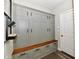 View of mudroom with built in gray cabinets with a stained wood bench and black hardware at 17390 Tribute Row, Noblesville, IN 46060