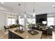 Kitchen island featuring stone countertops, stylish pendant lighting, and stainless steel sink with views of the dining area at 1892 Ponsonby Dr, Westfield, IN 46074