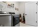 Well-equipped laundry room featuring modern washer and dryer, storage shelves, and tiled floor at 1892 Ponsonby Dr, Westfield, IN 46074