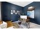 Home office boasts dark blue walls, modern desk, and a comfortable leather sofa at 1892 Ponsonby Dr, Westfield, IN 46074