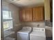 Functional laundry room with washer, dryer, and overhead cabinets at 1919 Manor Dr, Lebanon, IN 46052