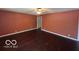 Empty Living room with dark wood floors and rust colored walls at 1919 Manor Dr, Lebanon, IN 46052
