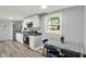Eat-in kitchen with white cabinets, stainless steel appliances, and a large window showcasing the yard at 217 W Burnside Ave, Fairland, IN 46126