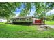 Relaxing backyard with a covered deck area for outdoor living and entertaining amidst mature trees at 217 W Burnside Ave, Fairland, IN 46126