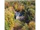 Beautiful aerial view of a stone home surrounded by vibrant fall foliage and mature trees at 2421 W 39Th St, Indianapolis, IN 46228