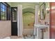 Bathroom with a pedestal sink, vintage tile and a large window allowing natural light at 2421 W 39Th St, Indianapolis, IN 46228