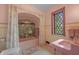 Charming bathroom with a pink sink and tub, accented by vintage tile work and a lattice window at 2421 W 39Th St, Indianapolis, IN 46228