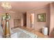 Spacious bedroom with hardwood floors, area rug, chandelier, and access to a bathroom and closet at 2421 W 39Th St, Indianapolis, IN 46228