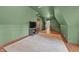 The green bedroom has hardwood floors and leads to the hallway with wood railing at 2421 W 39Th St, Indianapolis, IN 46228