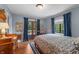 Bedroom featuring a four post bed, blue walls, wood floors, curtains and a view to the outside at 2421 W 39Th St, Indianapolis, IN 46228