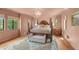 Bedroom featuring a four post bed, wood floors, light pink walls, chandelier, a bench and many windows at 2421 W 39Th St, Indianapolis, IN 46228