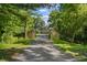 Lush greenery frames the estate entrance, leading to a stone home nestled in the distance at 2421 W 39Th St, Indianapolis, IN 46228