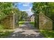 Gated estate entrance with a long driveway leading to an elegant stone home at 2421 W 39Th St, Indianapolis, IN 46228